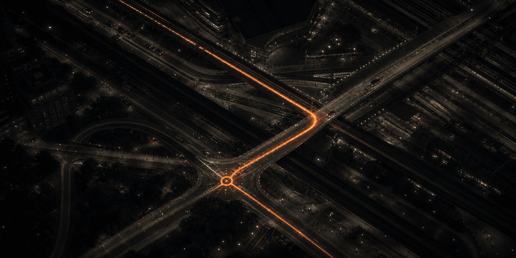 Intersecting city routes at night with one illuminated orange path